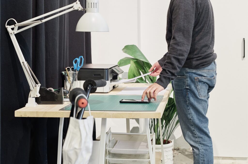 Male employee printing documents on the office desk